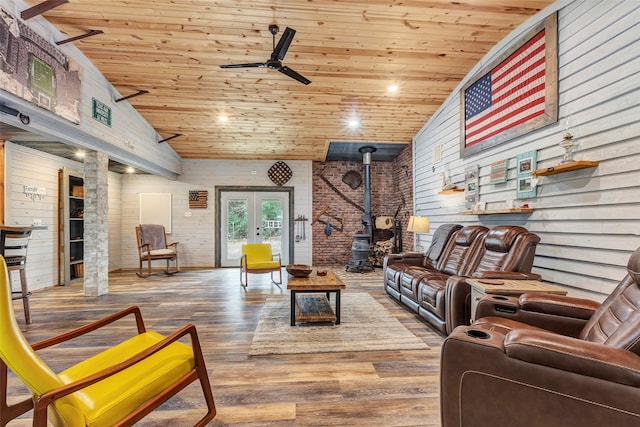 living area with ceiling fan, wood finished floors, wood ceiling, french doors, and a wood stove