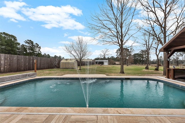 view of pool with a fenced backyard, a lawn, a fenced in pool, and an outbuilding