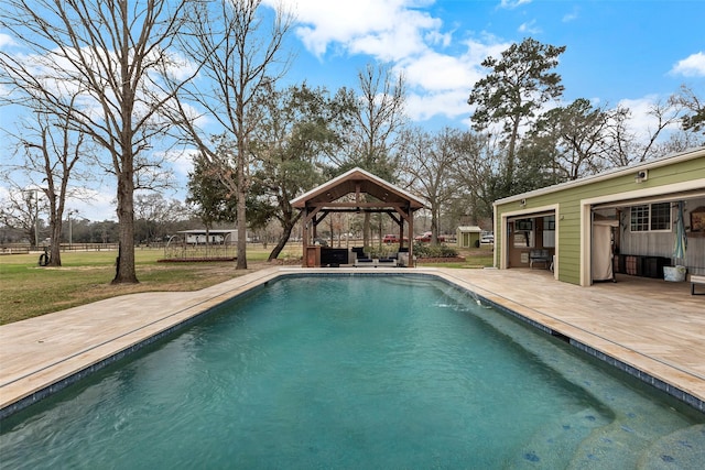 pool featuring a storage structure, an outdoor structure, a gazebo, a lawn, and a patio area