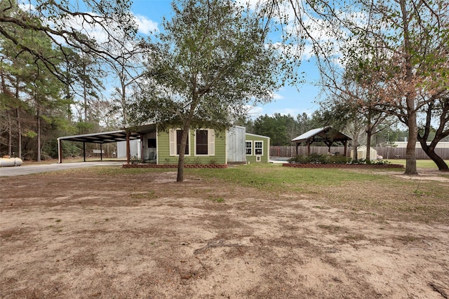 exterior space with driveway, a gazebo, fence, a yard, and a carport