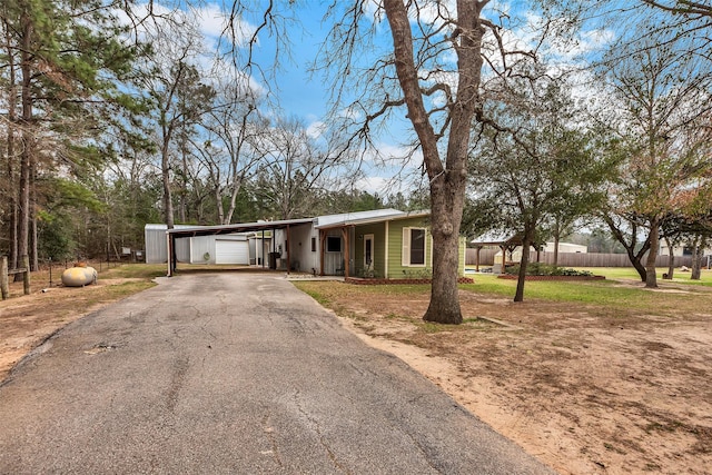 view of front facade with an attached carport, driveway, and fence