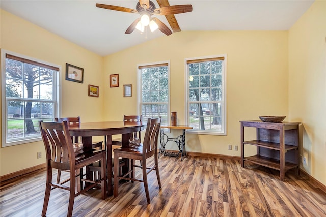 dining room featuring a ceiling fan, lofted ceiling with beams, baseboards, and wood finished floors