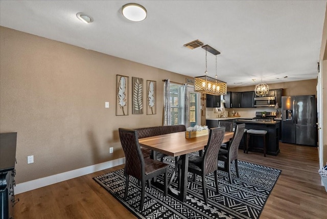 dining area featuring dark wood-type flooring, visible vents, and baseboards