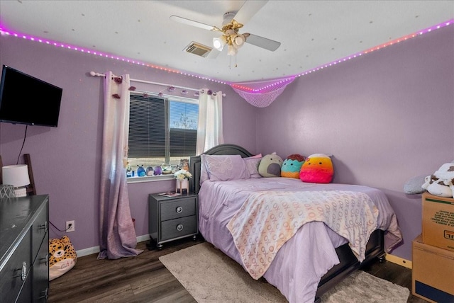 bedroom featuring ceiling fan, dark wood finished floors, visible vents, and baseboards