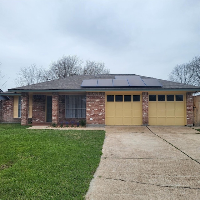 single story home featuring a front yard, solar panels, and brick siding