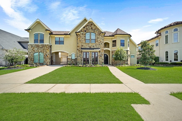 view of front of house with stone siding, french doors, a front yard, and stucco siding