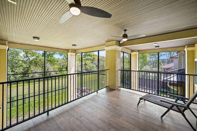 unfurnished sunroom with a ceiling fan and a healthy amount of sunlight