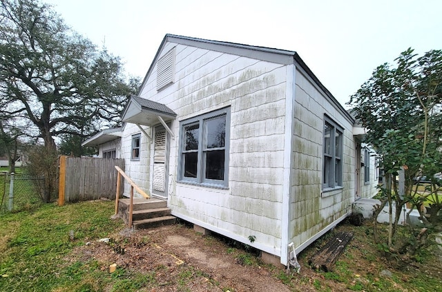 view of side of home featuring fence