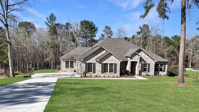 view of front of property with driveway, a shingled roof, a front yard, and brick siding