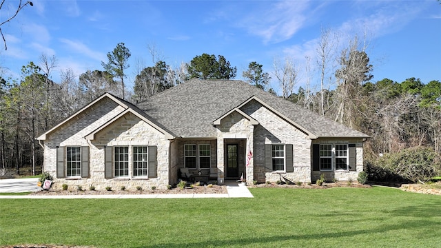 view of front of house featuring stone siding, a shingled roof, a front lawn, and brick siding