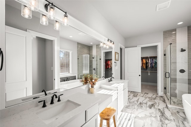 full bathroom with marble finish floor, a spacious closet, a stall shower, and a sink