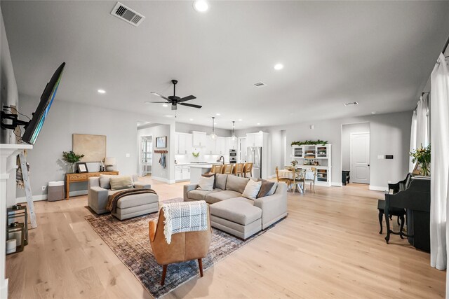 living room with recessed lighting, visible vents, and light wood-style floors