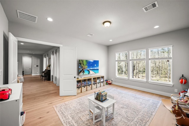 living area with light wood-style floors, recessed lighting, and visible vents