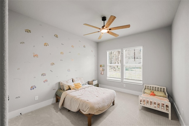 bedroom with light carpet, ceiling fan, and baseboards