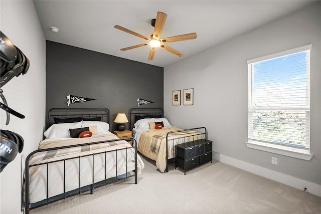 carpeted bedroom with a ceiling fan and baseboards