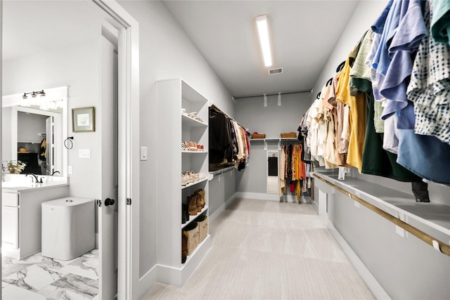 spacious closet with marble finish floor, visible vents, and a sink