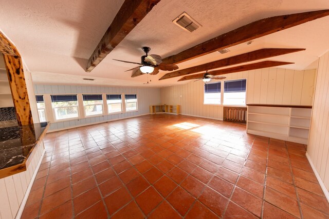 1131 Whispering Sands St, Port Aransas, TX 78373 - unfurnished living room featuring a healthy amount of sunlight, visible vents, and beam ceiling