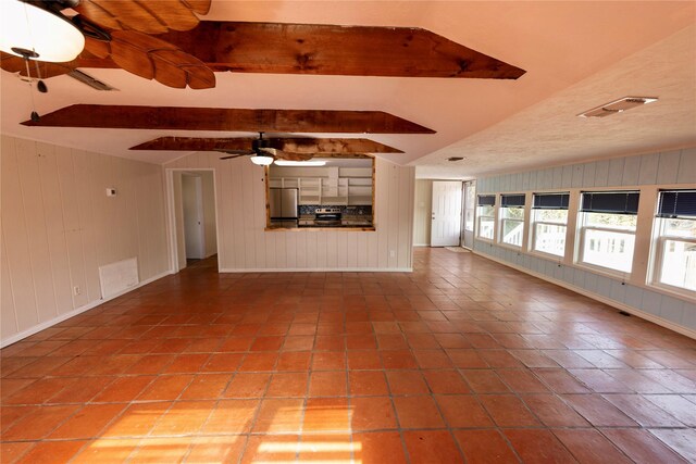 1131 Whispering Sands St, Port Aransas, TX 78373 - unfurnished living room featuring a ceiling fan, visible vents, lofted ceiling with beams, and baseboards