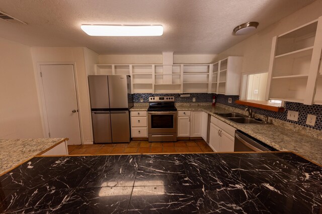 1131 Whispering Sands St, Port Aransas, TX 78373 - kitchen with open shelves, stainless steel appliances, decorative backsplash, white cabinetry, and a sink