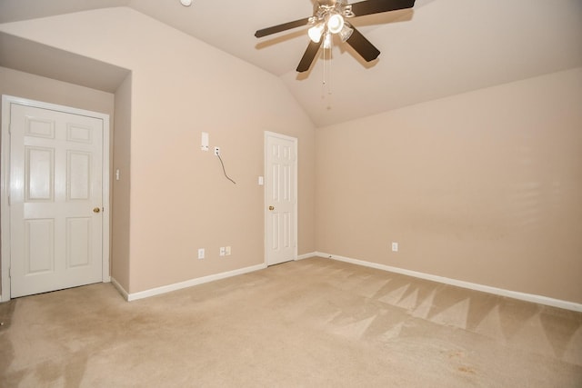 unfurnished room with lofted ceiling, ceiling fan, baseboards, and light colored carpet