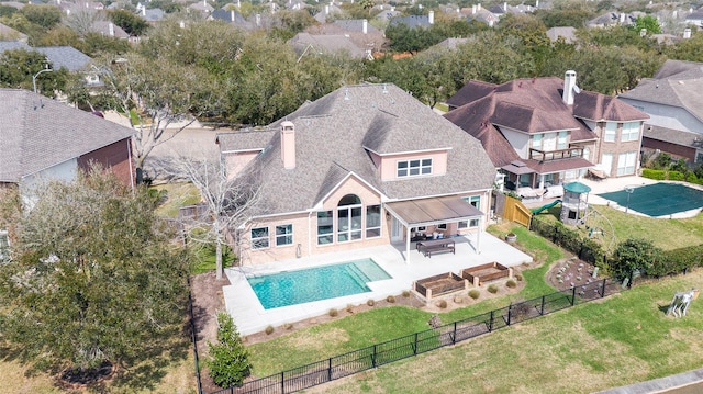 exterior space featuring roof with shingles, a yard, a fenced backyard, a chimney, and a patio area