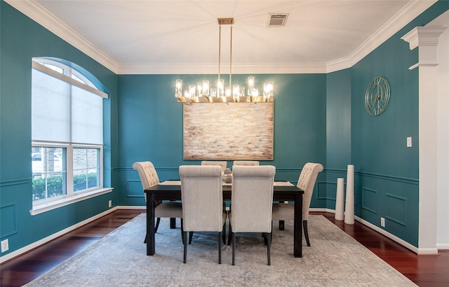 dining area with crown molding, wood finished floors, visible vents, and wainscoting