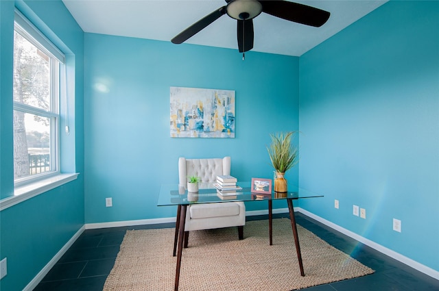 sitting room featuring dark tile patterned flooring, a ceiling fan, and baseboards