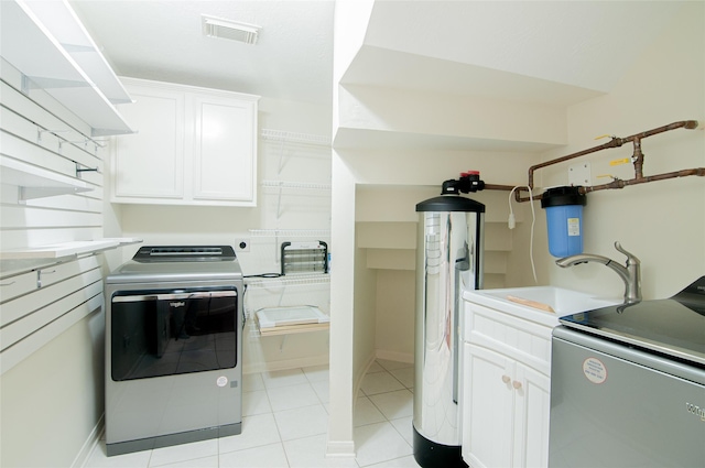 laundry room with a sink, visible vents, cabinet space, and washing machine and clothes dryer