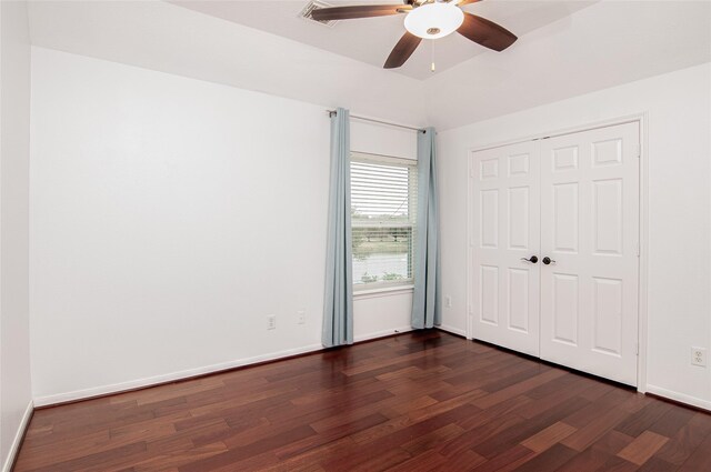 unfurnished bedroom with a ceiling fan, dark wood-style floors, baseboards, and a closet