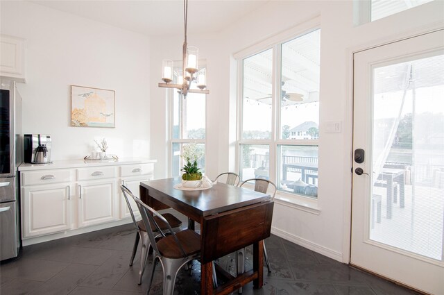 dining space with baseboards and a notable chandelier