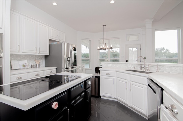 kitchen with tasteful backsplash, light countertops, appliances with stainless steel finishes, white cabinetry, and a sink