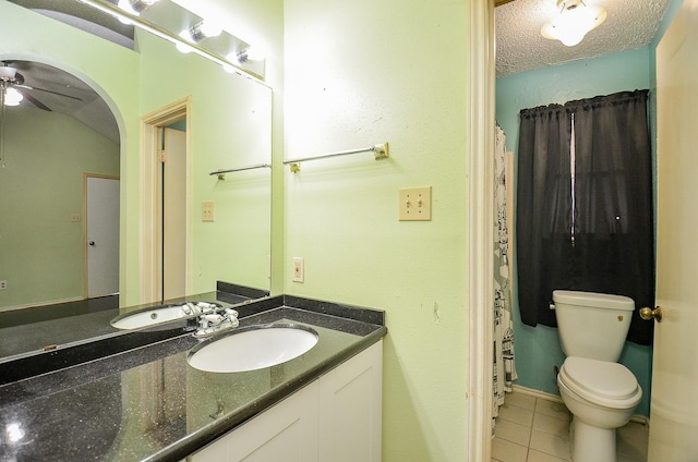 full bath featuring toilet, ceiling fan, tile patterned floors, a textured ceiling, and vanity