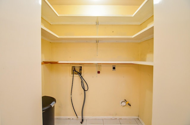 clothes washing area featuring washer hookup, hookup for a gas dryer, hookup for an electric dryer, and light tile patterned floors