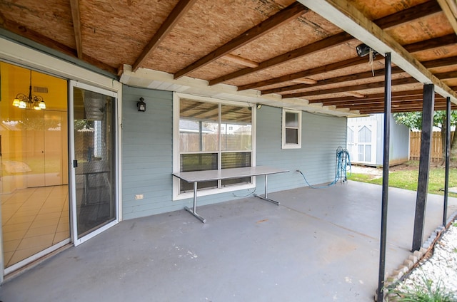 view of patio / terrace with an outbuilding, fence, and a storage shed