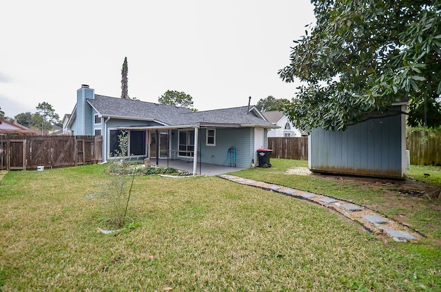 back of house featuring a chimney, a patio area, a yard, and a fenced backyard