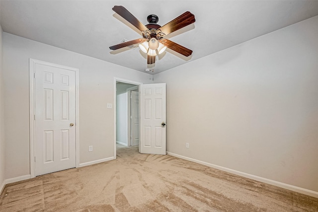 unfurnished bedroom featuring light carpet, baseboards, and a ceiling fan