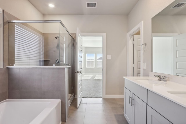 bathroom featuring a garden tub, tile patterned flooring, a sink, and visible vents