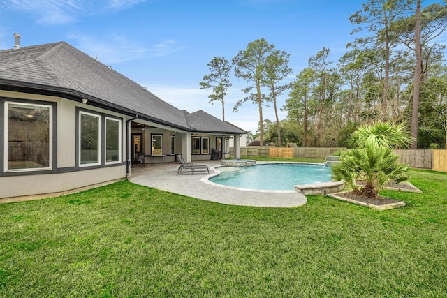 view of swimming pool featuring a pool with connected hot tub, a fenced backyard, a lawn, and a patio