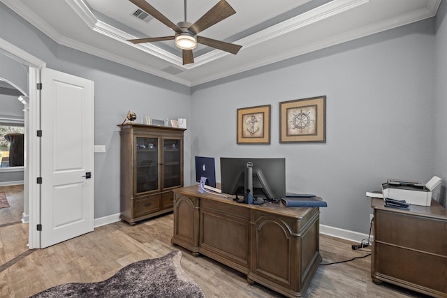 home office with light wood-style floors, ceiling fan, a raised ceiling, and crown molding