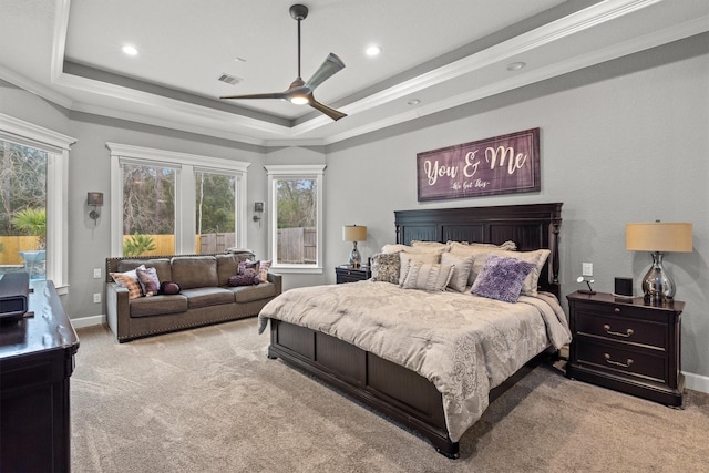 bedroom with light colored carpet, a tray ceiling, and visible vents