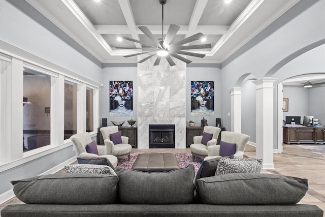 living room featuring decorative columns, arched walkways, coffered ceiling, a ceiling fan, and beam ceiling