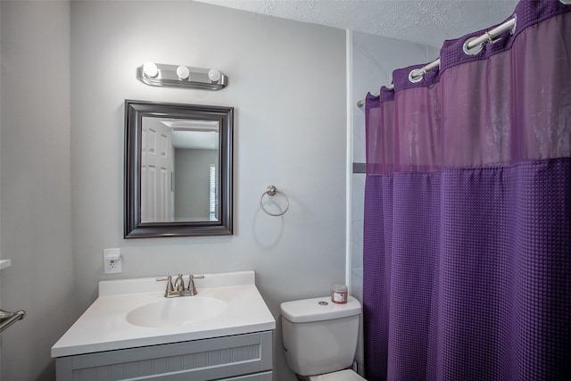 bathroom featuring a shower with curtain, vanity, toilet, and a textured ceiling