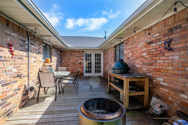 deck with a fire pit, french doors, and outdoor dining area