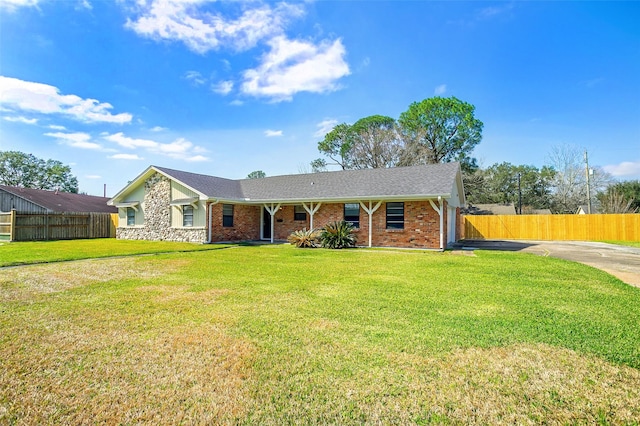 single story home featuring a front lawn, fence, and brick siding