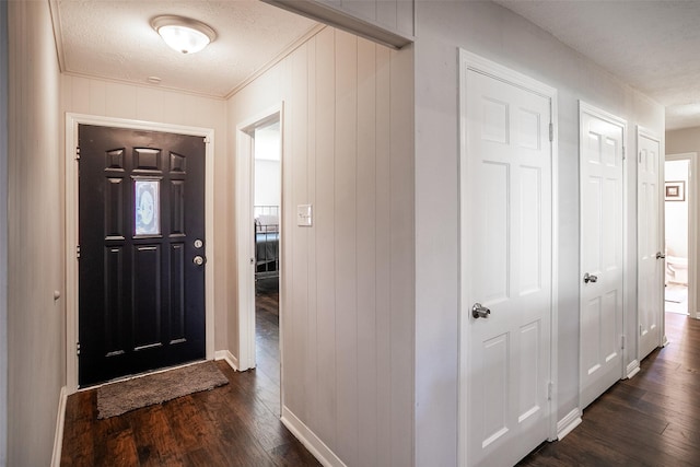 entrance foyer featuring dark wood-style floors, a textured ceiling, and baseboards