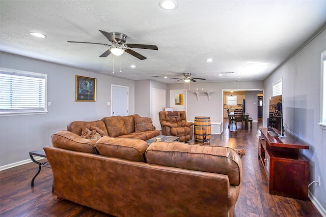 living area with a textured ceiling, baseboards, dark wood-type flooring, and recessed lighting