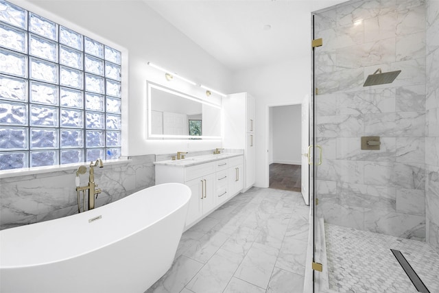 full bath featuring marble finish floor, a marble finish shower, a freestanding bath, and vanity