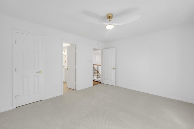 unfurnished bedroom with ceiling fan, baseboards, connected bathroom, and light colored carpet