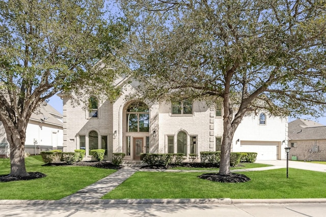 view of front of house with a garage, concrete driveway, and a front lawn