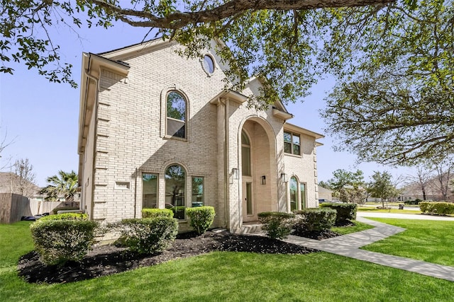 view of front facade with a front yard and brick siding